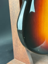 Close-up of a guitar with a sunburst finish on a wooden surface
