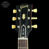 Gibson guitar headstock with tuning pegs on a black background