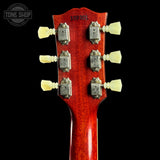 Close-up of a red guitar headstock with tuning pegs on a black background, featuring 'Tone Shop' logo.