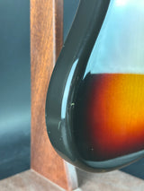 Close-up of a guitar with a sunburst finish on a wooden surface