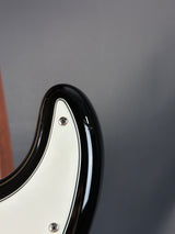 Close-up of a guitar neck with a black and white design on a gray background