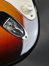 Close-up of a guitar with a tone control knob on a dark background