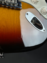 Close-up of a guitar's pickguard and tuning pegs on a dark background