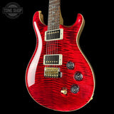 A red electric guitar with a flamed maple top and gold hardware, shown against a black background with a Tone Shop watermark in the top left corner.