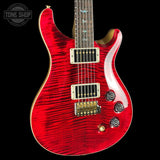 A red flamed maple electric guitar with gold hardware and a black pickguard, shown against a solid black background. A Tone Shop watermark is visible in the top left corner.