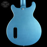 Blue electric guitar body with 'Tone Shop' logo in the corner.
