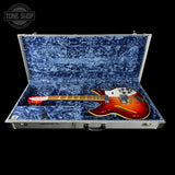 Electric guitar in a blue-lined case with 'Tone Shop' branding.