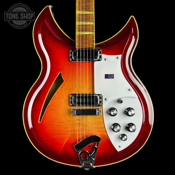 Electric guitar with a red and white design on a black background, featuring the Tone Shop logo.