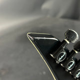Close-up of a guitar pick with a brand logo on a dark background