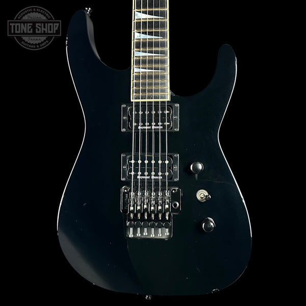 Black electric guitar on a black background with 'Tone Shop' logo.