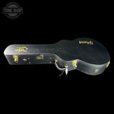 Black guitar case with gold accents on a black background, featuring the 'Tone Shop' logo.
