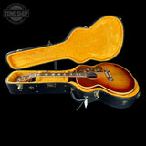 Acoustic guitar in a black case with 'Tone Shop' branding.