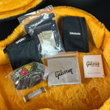 Gibson guitar care kit with humidiPak, cloth, and other items on a yellow surface