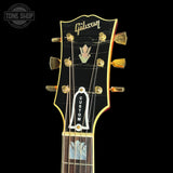 Gibson guitar headstock with brand logo on a black background