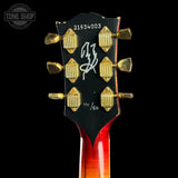 Guitar headstock with gold tuning pegs on a black background, featuring 'Tone Shop' branding.