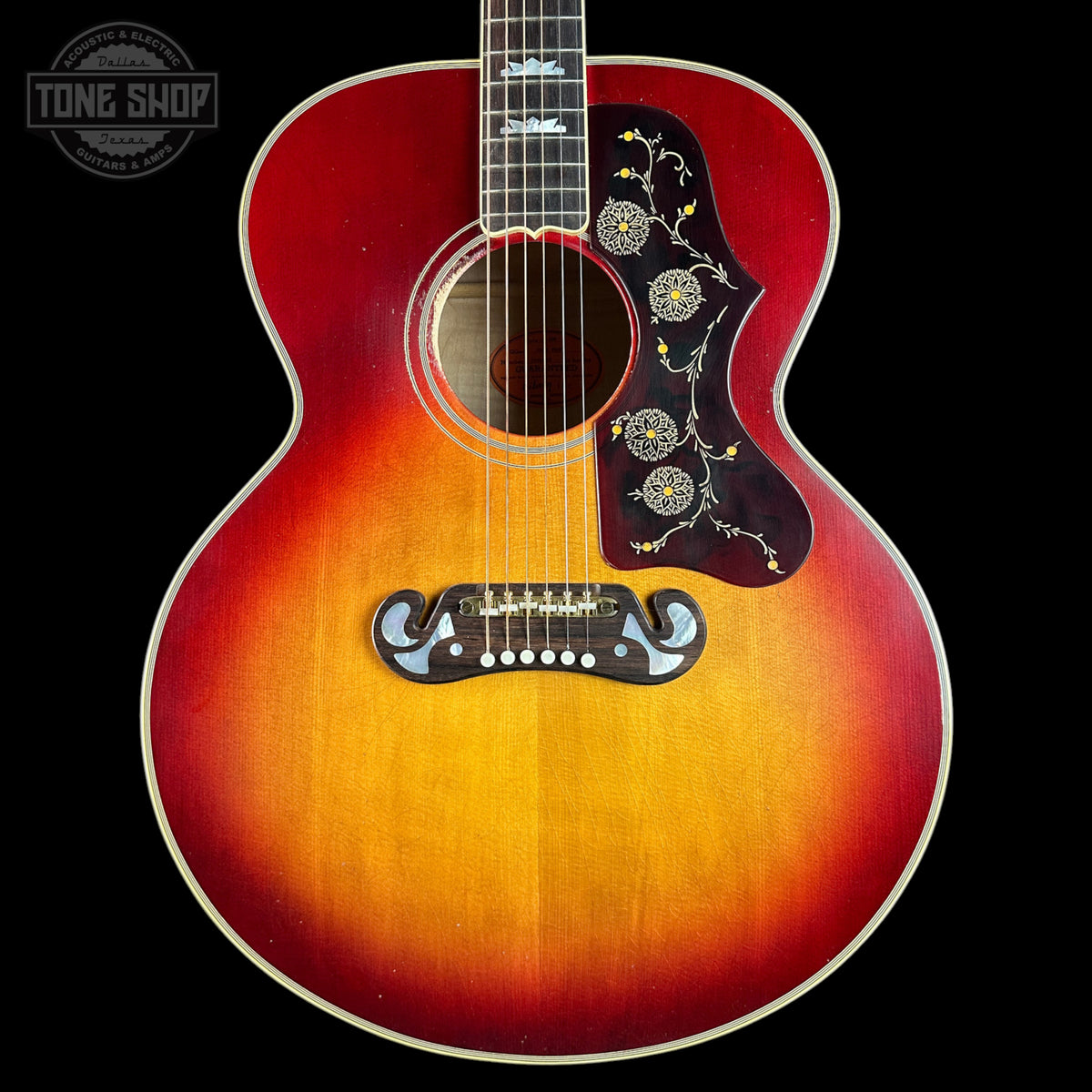 Acoustic guitar with sunburst finish on a black background, featuring 'Tone Shop' logo.