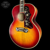 Acoustic guitar with sunburst finish on a black background, featuring 'Tone Shop' logo.