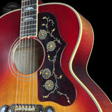 Close-up of a red acoustic guitar with floral design on a black background