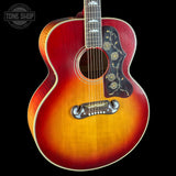 Acoustic guitar with a sunburst finish on a black background, featuring the Tone Shop logo.