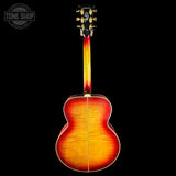 A guitar with a sunburst finish on a black background, featuring the Tone Shop logo.