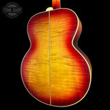 Back view of a sunburst acoustic guitar with 'Tone Shop' logo.