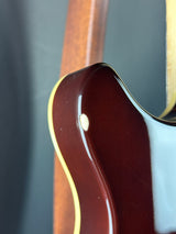 Close-up of a guitar's neck and headstock on a dark background