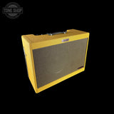 Yellow guitar amplifier with 'Tone Shop' logo in the corner
