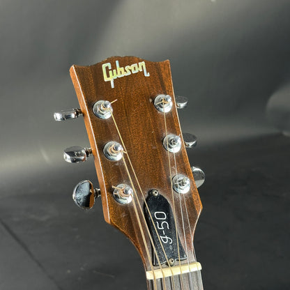 Gibson guitar headstock with tuning pegs on a dark background