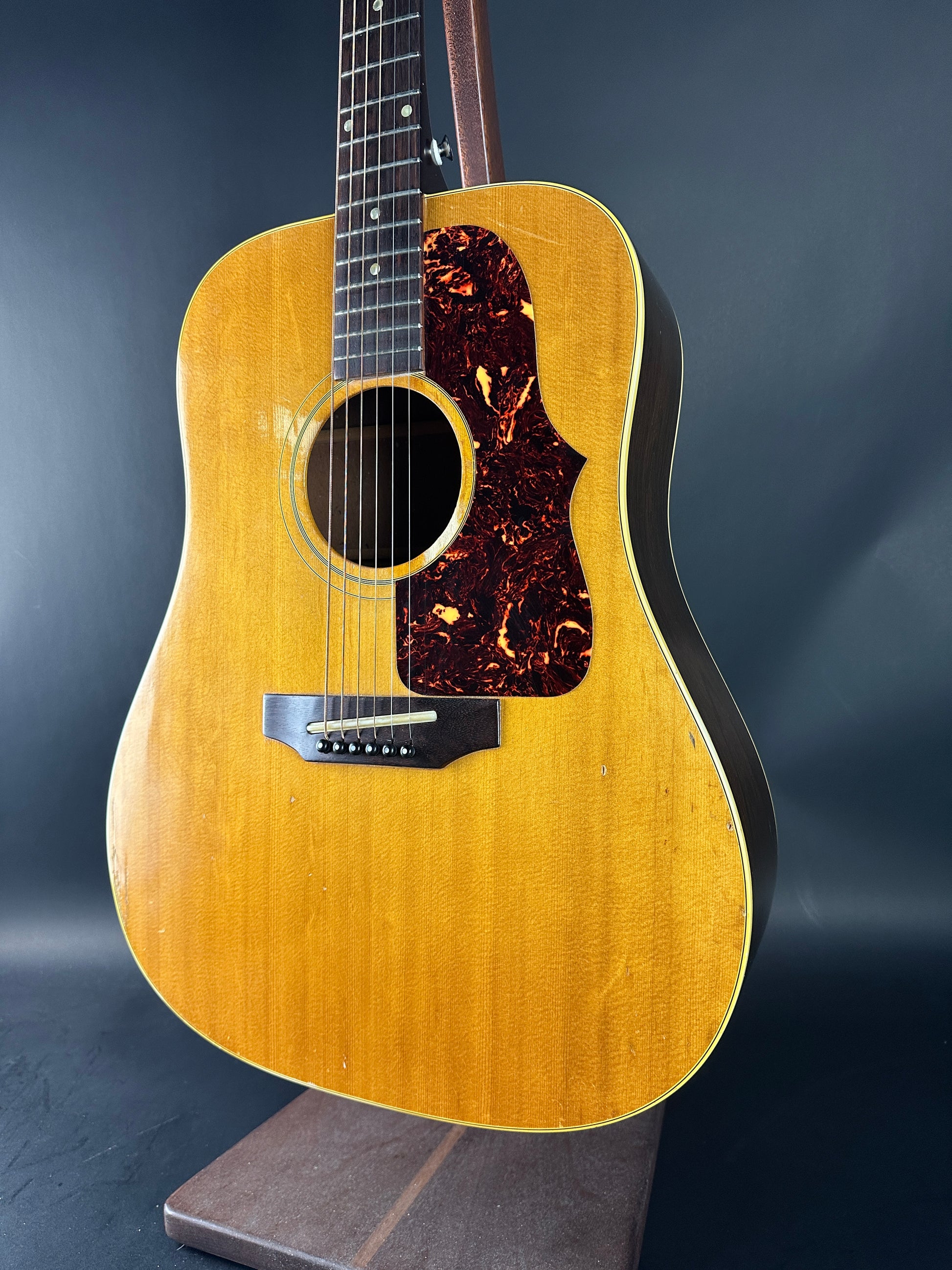 Acoustic guitar with a wooden finish on a dark background