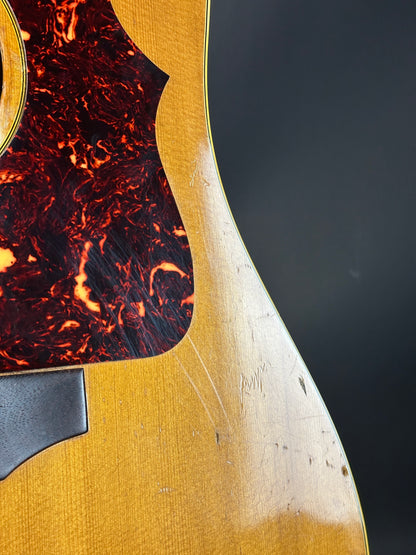 Close-up of a guitar with tortoiseshell pickguard and gold finish