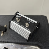 Fender guitar pedal on a black amplifier with a gray background