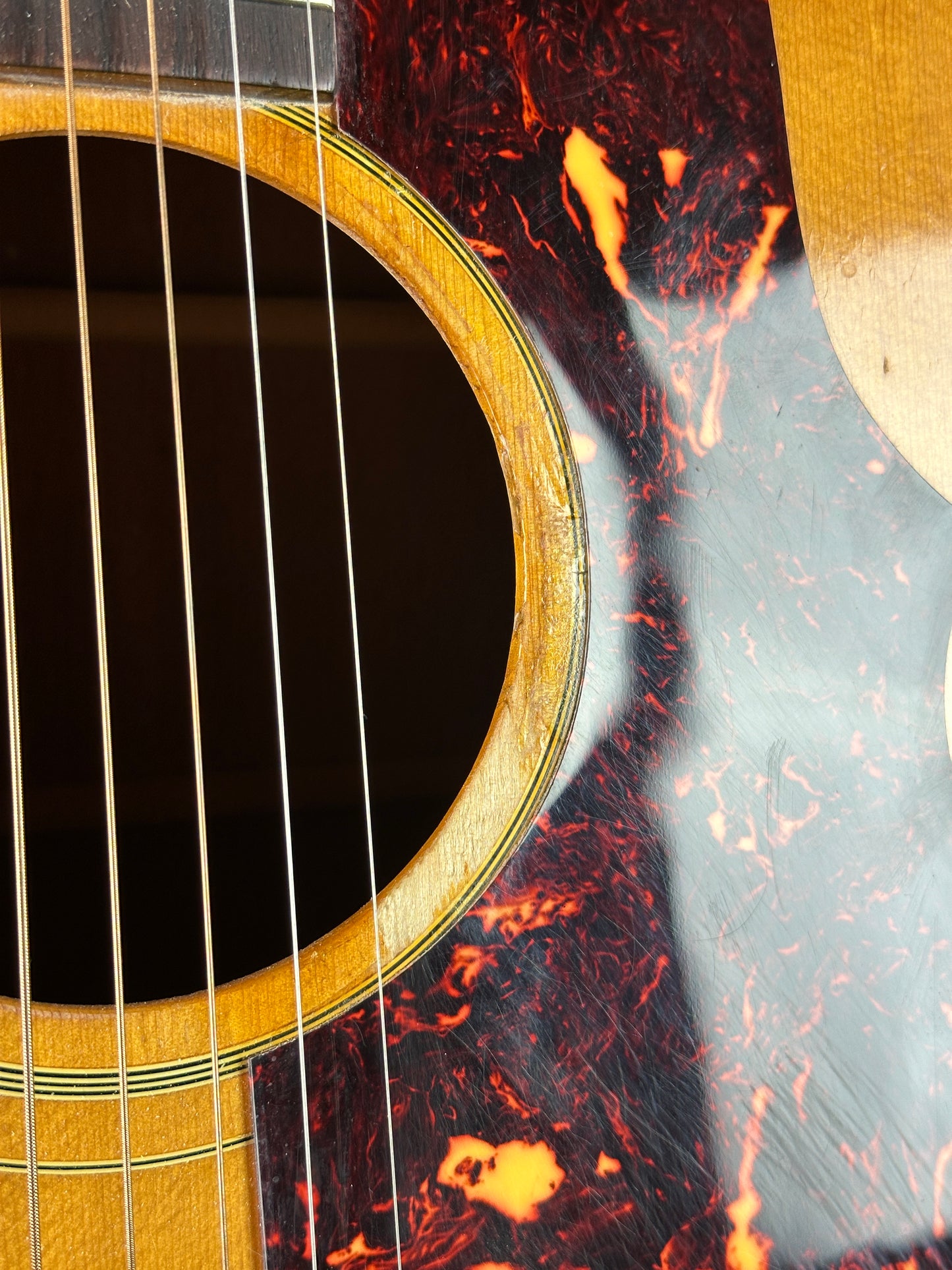 Close-up of an acoustic guitar's soundhole and tortoiseshell finish