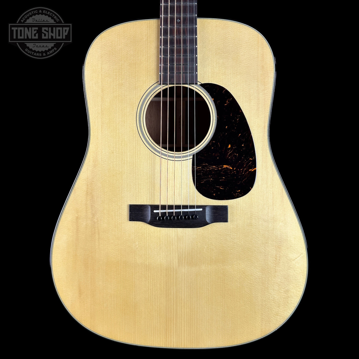Acoustic guitar with a visible brand logo on a black background