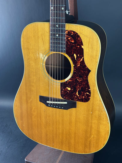 Acoustic guitar with a wooden finish on a dark background