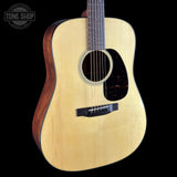 Acoustic guitar with a visible brand logo on a black background
