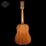 Back view of a wooden acoustic guitar on a black background with 'Tone Shop' logo.