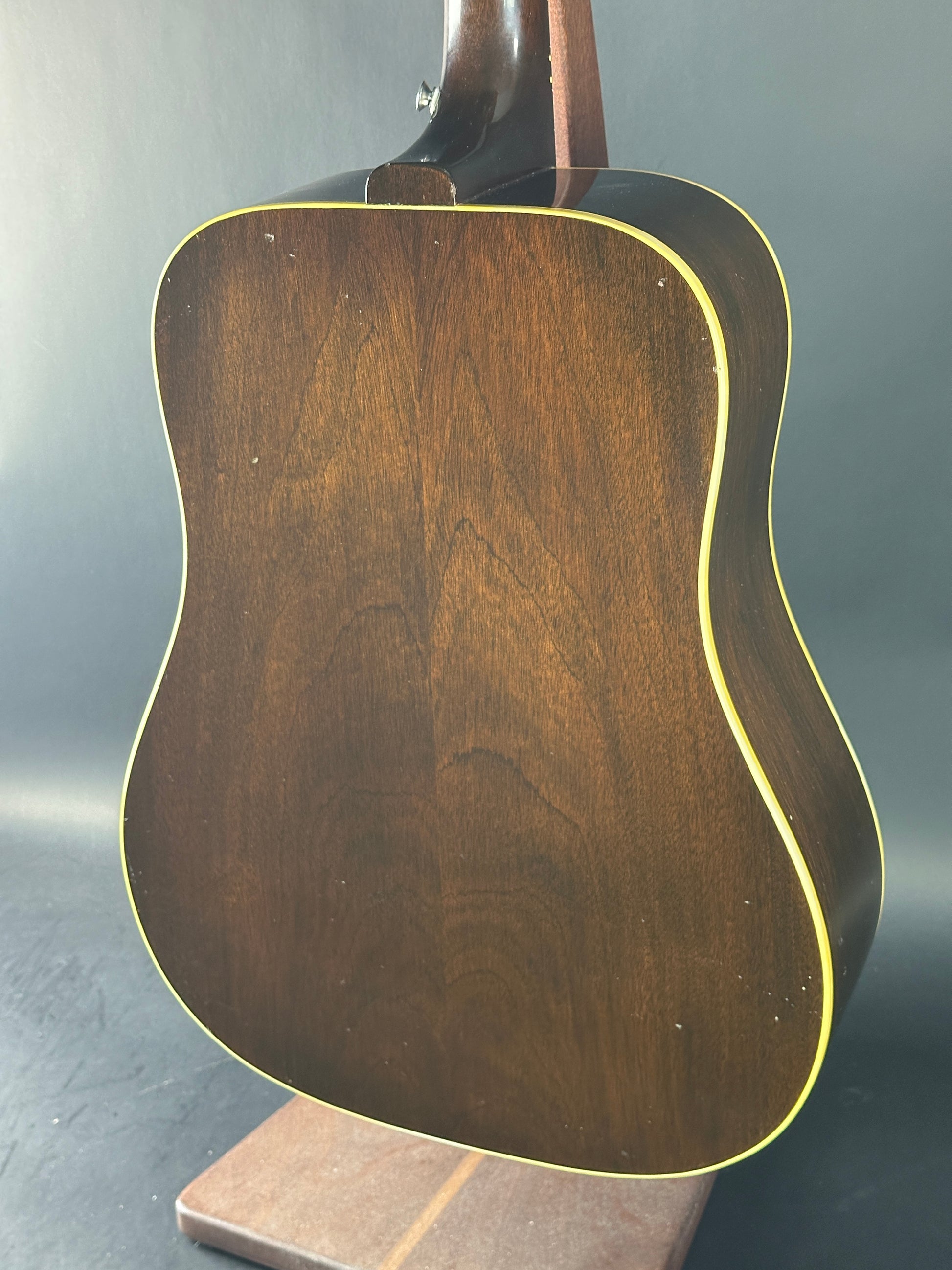 Close-up of a wooden acoustic guitar body on a dark background