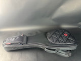Black guitar case with quilted design on a gray surface