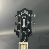 Guitar headstock withGuild logo on a gray background