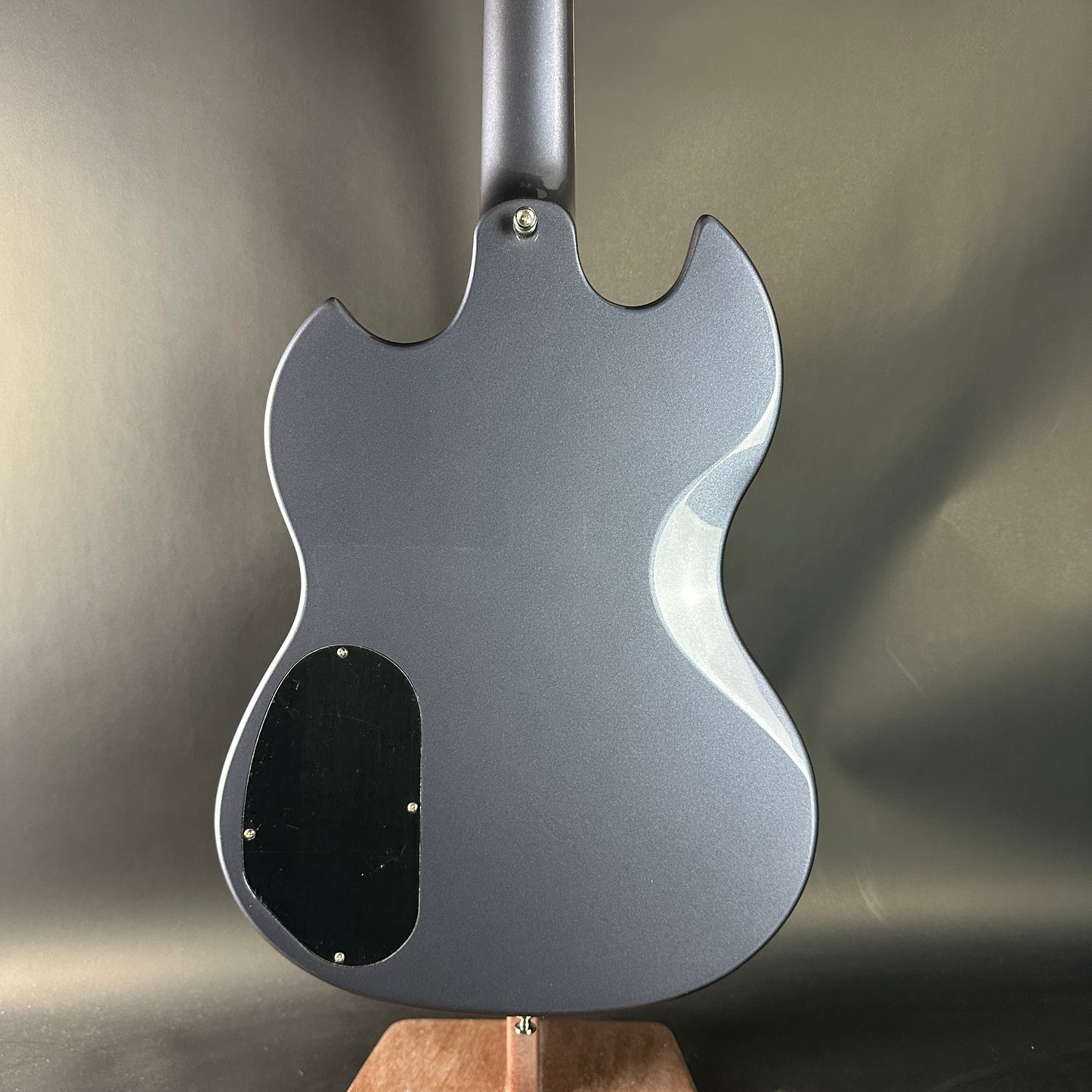 Back view of a gray electric guitar on a neutral background
