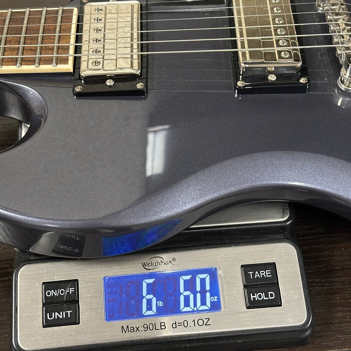 Guitar on a digital scale displaying weight