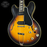 Electric guitar with a sunburst finish on a black background, featuring the Tone Shop logo.