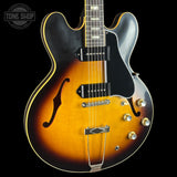 Electric guitar with a sunburst finish on a black background, featuring the Tone Shop logo.