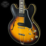 Electric guitar with a sunburst finish on a black background, featuring the Tone Shop logo.