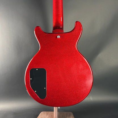 Red electric guitar body on a stand with a gray background