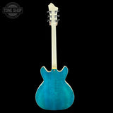 Blue electric guitar on a black background with 'Tone Shop' logo.