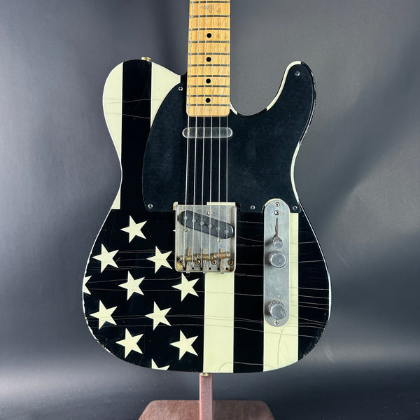Black electric guitar with white star pattern on a dark gray background
