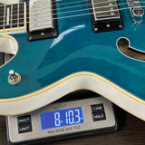 Blue electric guitar on a digital scale displaying weight