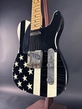 Electric guitar with a black and white flag design on a dark background