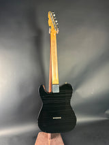 Black electric guitar with wooden neck on a gray background